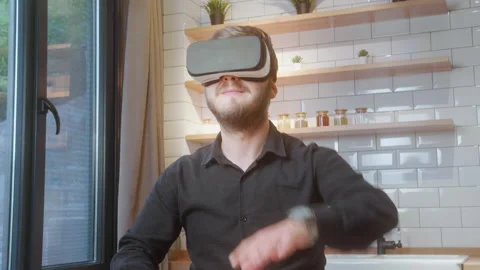 Young man wearing virtual reality headset and interacting with digital cont.. Vídeo Stock 310877576