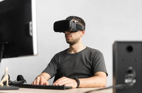 Young man wearing virtual reality goggles headset, vr box and sitting in the Stock Photos