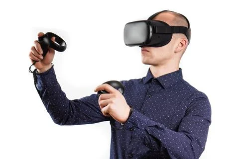 Young man wearing virtual reality glasses during a working break. Behind them Stock Photos
