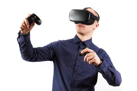 Young man wearing virtual reality glasses during a working break. Behind them Stock Photos