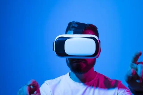 Young man wearing virtual reality goggles and speasing with a friends in the Stock Photos