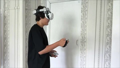 Young man wearing VR glasses interacting with 3d objects in augmented virtual 動画素材 313187111
