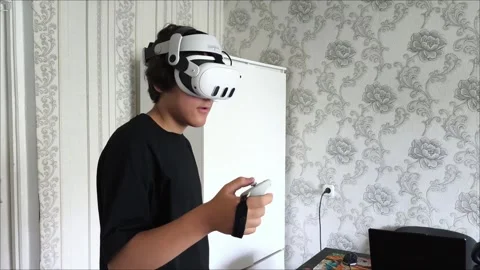 Young man wearing VR glasses interacting with 3d objects in augmented virtual Stock Footage 313187645