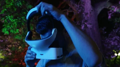 Young man wearing VR headset gadget and immersing into virtual reality Stock Footage 107125793