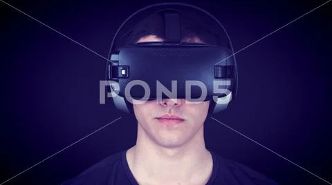 Young Man Wearing VR Headset And Experiencing Virtual Reality - Blue Concept Stock Photos