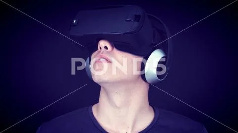Young Man Wearing VR Headset And Experiencing Virtual Reality - Blue Concept Stock Photos