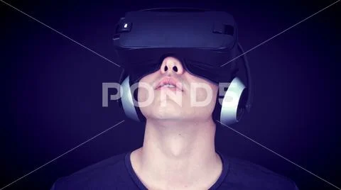 Young Man Wearing VR Headset And Experiencing Virtual Reality - Blue Concept Stock Photos