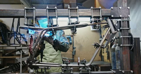 A young man welder in the workshop makes and connects metal structures for the Stock Footage 148646786