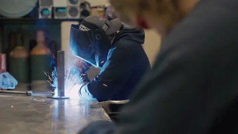 Young man welds two pieces of metal together Stock-Footage 103337743