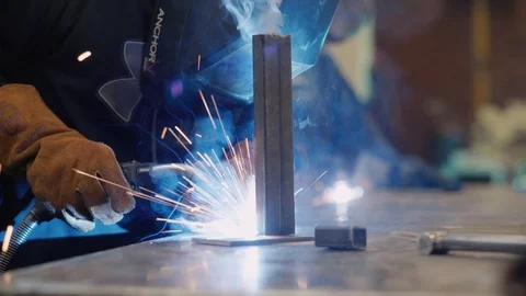 Young man welds two pieces of metal together Stock-Footage 103337979
