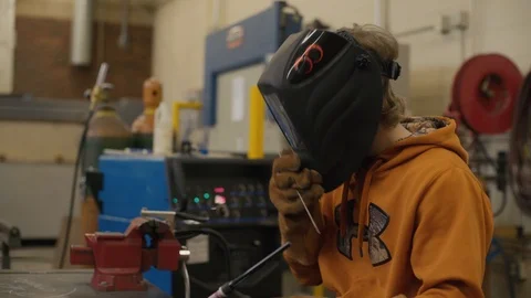 Young man welds two pieces of metal together Stock Footage 103338231