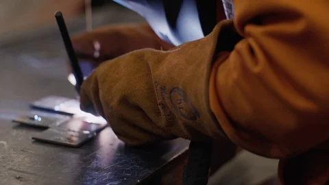 Young man welds two pieces of metal together Stock Footage 103339057