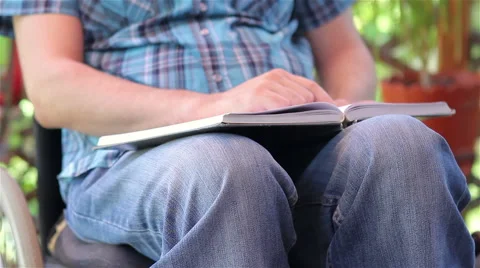 Young man in wheelchair reading Stock Footage 50647224