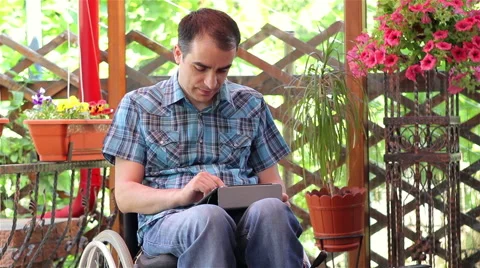 Young man on wheelchair using a tablet computer Stock Footage 50647727