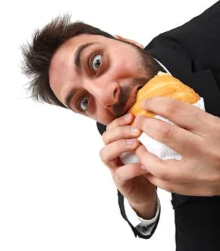 Young man while eating quickly a sandwich Stock Photos