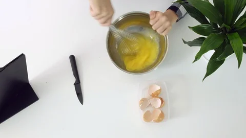 A young man whisk eggs. Closeup of chef whisking eggs in bowl Stock Footage 102553665