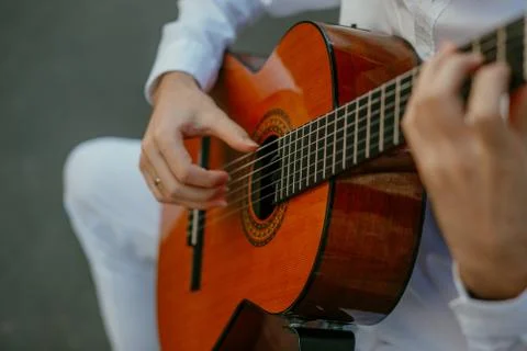 Young man in white playing classical guitar Stock Photos