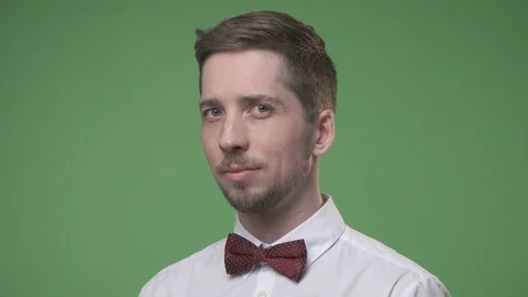 Young man in a white shirt with a bow tie against  chroma key Stock Footage 73153371