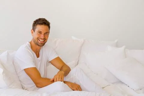 Young man on white sofa Stock Photos
