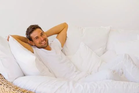 Young man on white sofa Stock Photos