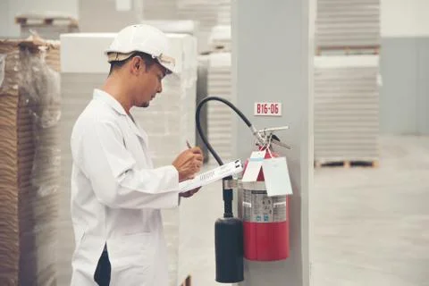 Young man white uniform checking safety equipment at store factory Stock-Fotos