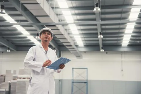 Young man white uniform checking stock at store factory Stock Photos