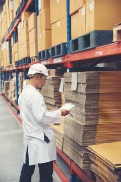Young man white uniform checking stock at store factory Stock Photos