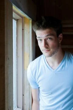 Young man at the window Stock Photos