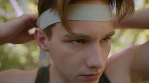 Young Man Winking While Loosening White Headband Over Forehead Close Up Stock Footage 316946052