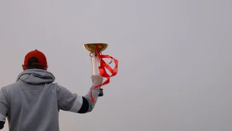 Young man with winner cup and red lines on the wind Stock Footage 87195101