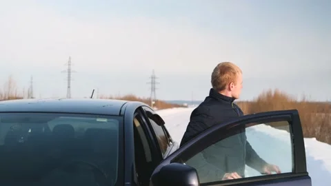 A young man in the winter on the car got lost and get out of the car. Stock Footage 150992841