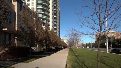 Young man in winter coat walking along sidewalk. A7R353 Stock Footage 96353775