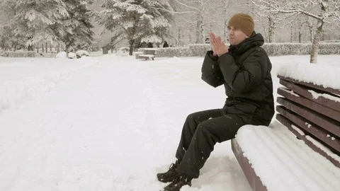 A young man in winter is cold in the forest near the spruce. Big snowfall. He's Stock Footage 71221806