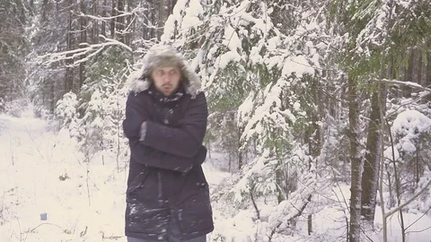A young man in winter forest freeze. He freezes, rubs his hands and bounces Stock Footage 83761789