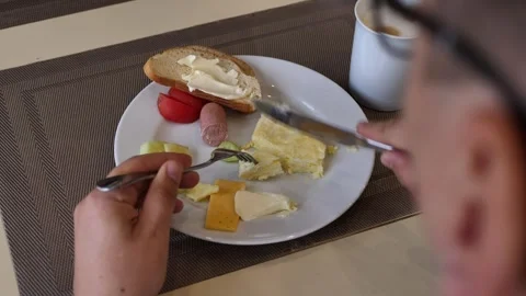 A young man without a face is having breakfast while sitting at a table in a Stock Footage 254223939