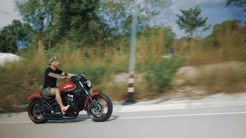 Young man without helmet riding his orange motorcycle on a highway, stabilizer Stock Footage 90273210