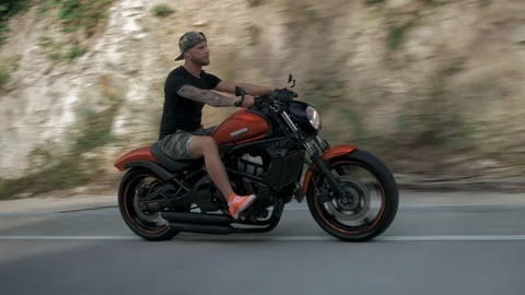 Young man without helmet riding his orange motorcycle on a highway, stabilizer Vídeo Stock 90275662