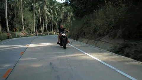 Young man without helmet riding his orange motorcycle, stabilized shot Stock-Footage 90283239
