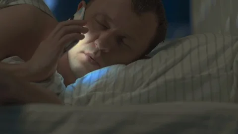Young man woke up at night with a mobile phone Stock Footage 130056421