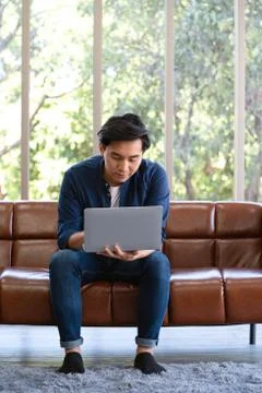 The young man wore comfortable clothes use laptop computer to search for jobs Stock Photos
