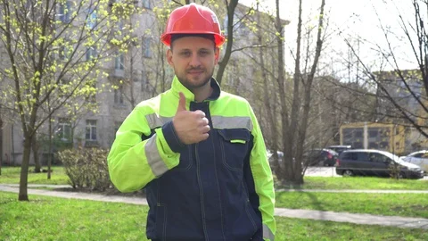 A young man in work clothes happily approves. Builder shows class. Stock Footage 130140153