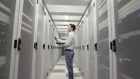 Young man at work inside a Dutch Datacenter corridor Stock Footage 294988014