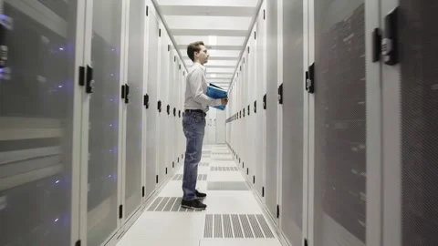 Young man at work inside a Dutch Datacenter corridor Stock Footage 294988086