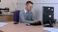 Young man at work mutitasking on phone and computer HD Footage