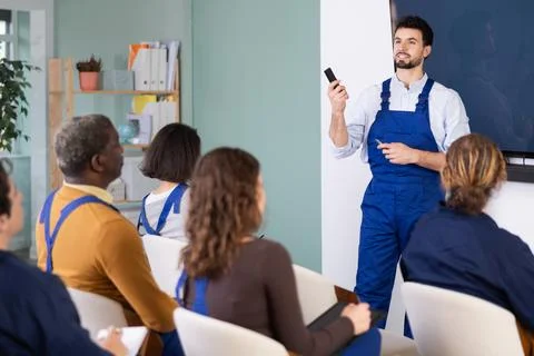 Young man worker gives lecture in auditorium Stock Photos