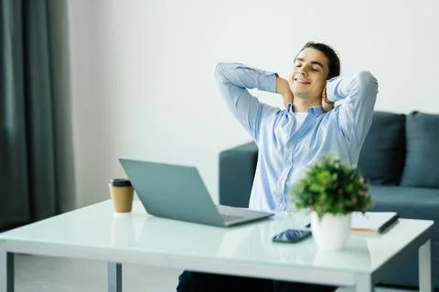 Young man worker having break and resting after solving task Stock Photos