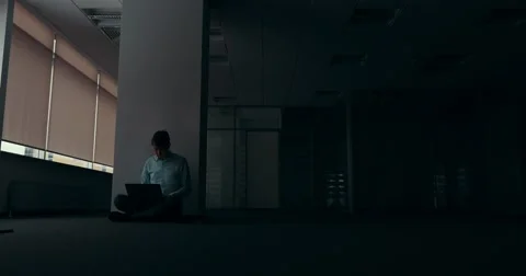 Young man working alone in empty office at night Видео 62993382