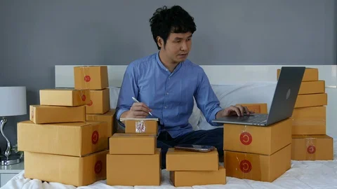 Young man working and using laptop computer to selling product online on a bed Video stock 130104027
