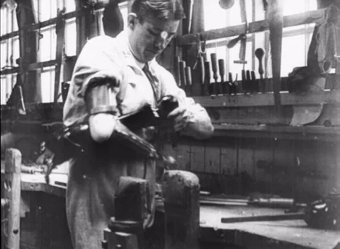 Young man working on artificial limb in J. E. Hanger workshop, England, 1916 Stock Footage 172219690