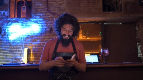 Young man, working in bar, using smartphone Stock Footage 126907686